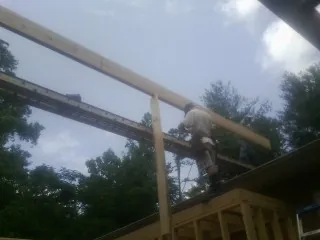 Carpenter setting a ridge beam over a new addition frame — Ice Dam Removal by Roofing Brothers in Marcus
