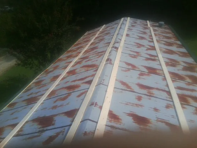 Rusted metal roof panels with new wood purlins before replacement — Storm Damage Roof Repair in Marcus by Roofing Brothers