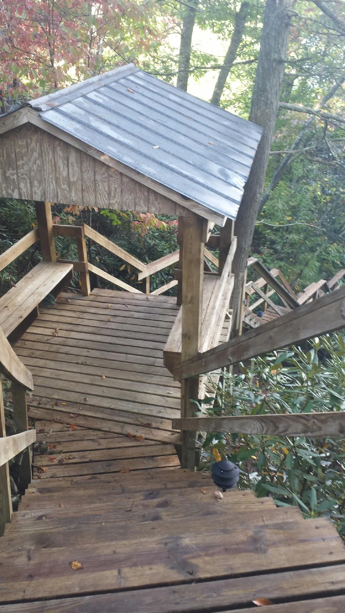 Metal roofed shelter over wooden steps on a wooded walkway — Skylight Repair & Installation work by our crew in Marcus