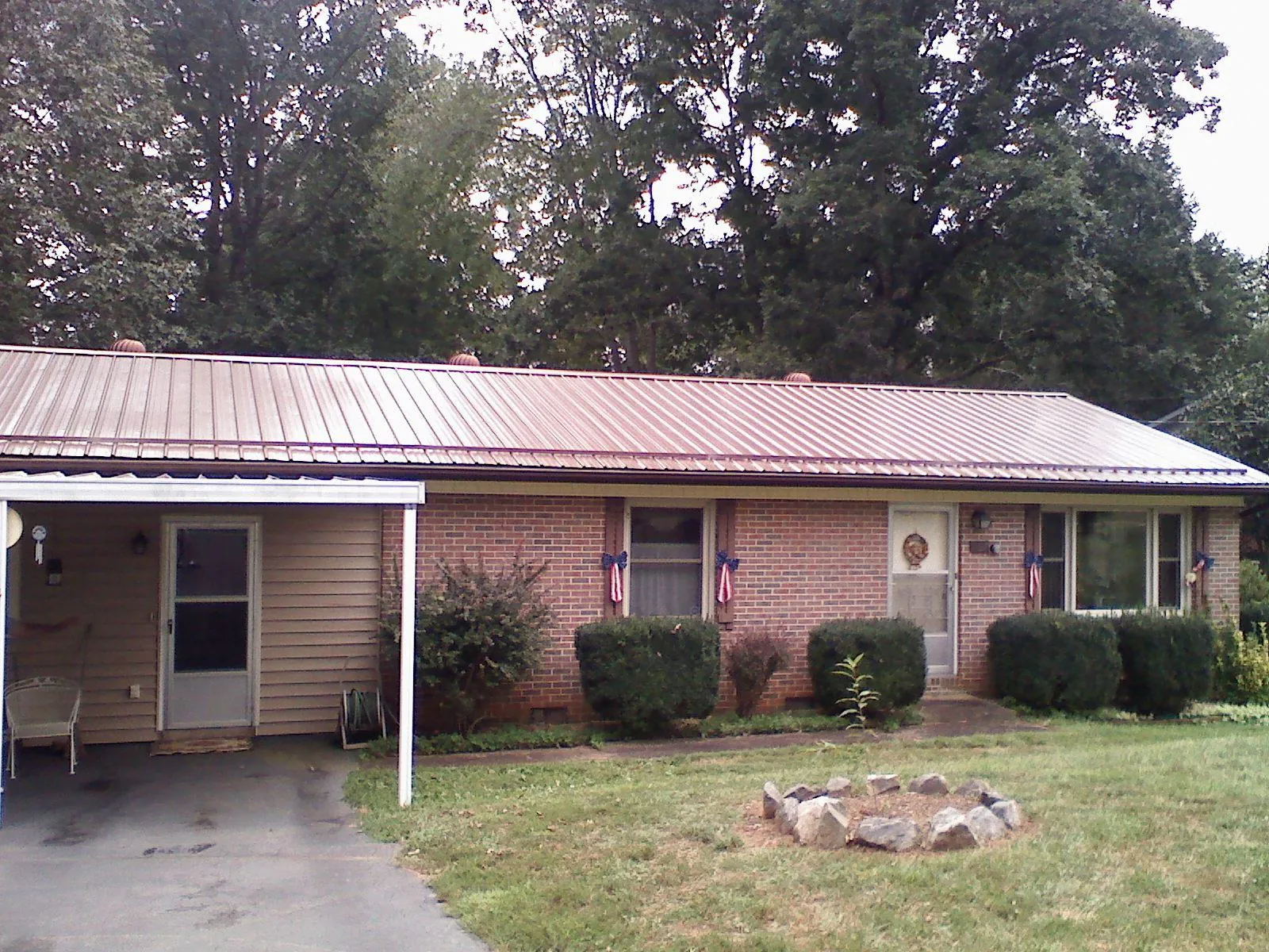 Bronze metal roof and carport on a brick ranch home — Roof Repair work by our crew in Marcus