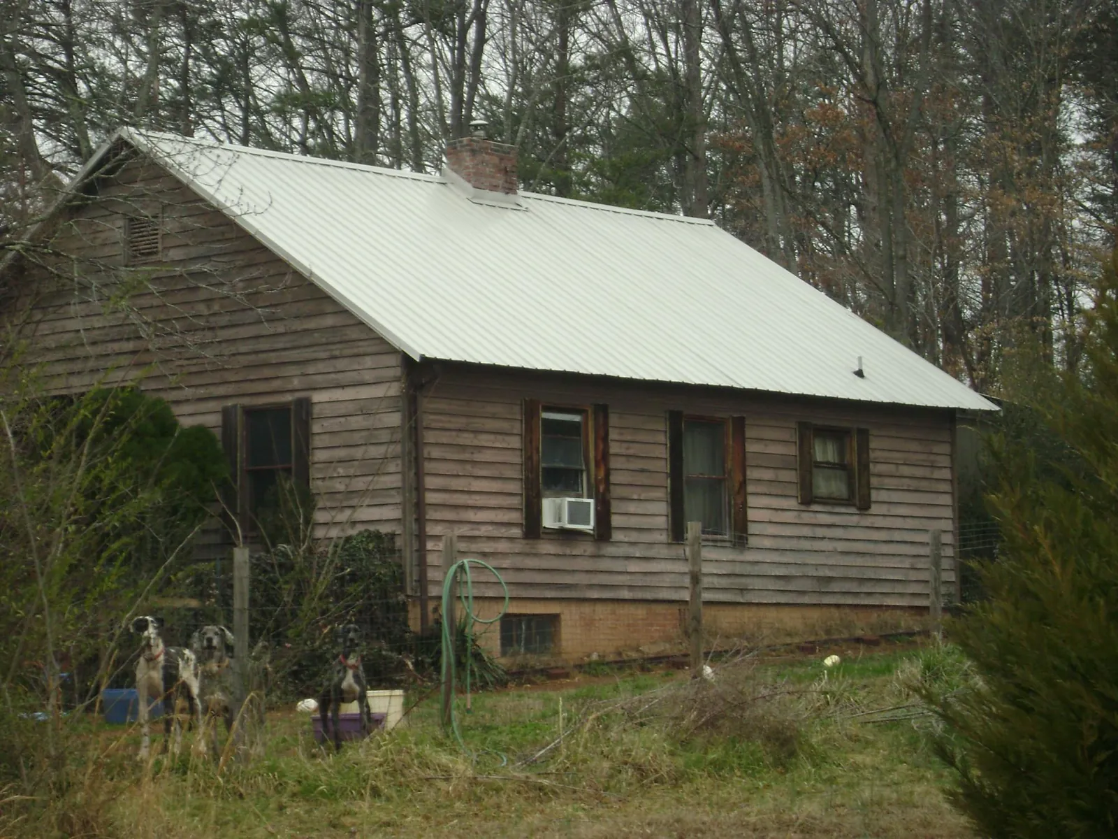 White metal roof on an old wood sided farmhouse, from a Metal Roof Installation job in Marcus